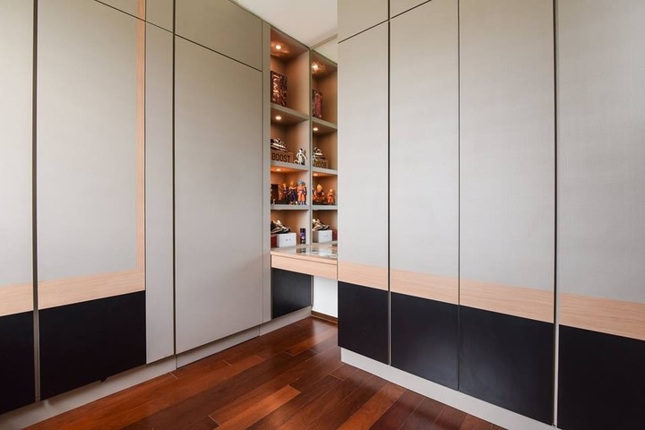 Elegant contemporary design by GI Design Sdn Bhd, featuring a minimalist Desa Park City home with sleek floor-to-ceiling storage solutions. The warm wooden floors complement the neutral palette, while hidden shelves add a functional yet sophisticated touch to the space. Experience the fusion of serenity and modern aesthetics in this exquisitely balanced interior. Perfect for those seeking a stylish, clutter-free living environment.