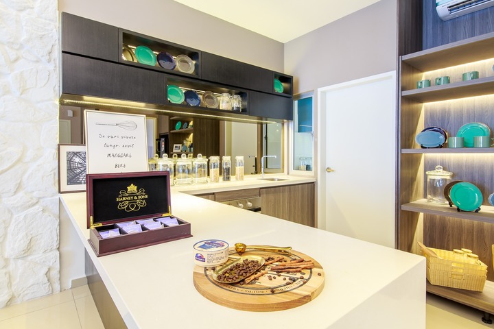 This kitchen from MIL Design & Construction's 2-Storey Link Villa at Hana Gardens, Jadehills captures a modern, French-Provencal aesthetic. White stone walls and sleek dark cabinetry complement the natural light, creating an inviting space. Pops of turquoise in dishware add a vibrant touch to the room, embodying the understated elegance ideal for Malaysian family homes.