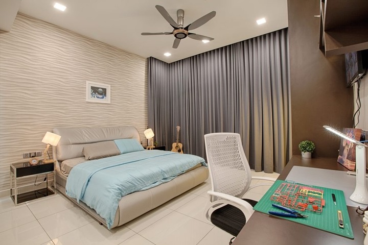 This elegant bedroom designed by GI Design Sdn Bhd showcases a contemporary style from their Semi Detached House project in Ambang Botanic 2. Featuring a neutral color palette, accentuated by soft blue bedding and rich grey curtains, the space balances warmth and sophistication. A sleek white chair and well-arranged shelf decor complement the comfortable, yet stylish ambiance, perfect for modern interior design enthusiasts.