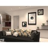 This modern living space by R Works, encapsulated in their 'RIMBAYU' portfolio, showcases a contemporary design theme with a neutral color palette of grey, white, and beige. The room features a sleek grey sofa adorned with patterned throw pillows, flanked by unique wall art pieces and complemented by tasteful shelving adorned with greenery. The ambience celebrates minimalism and comfort, ideal for anyone looking to infuse their home with modern Malaysian interior design elegance.