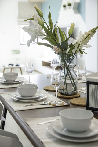 Reflecting Merge Design Studio's 'Isle of Karames' vision, this modern Scandinavian dining space invites serenity with its minimalist aesthetic. Subtle hues of blue and white harmonize with natural light, enhancing the room's calm ethos. Simplistic yet elegant table settings, paired with contemporary furnishings, epitomize understated luxury, ideal for those appreciating sleek interior design.