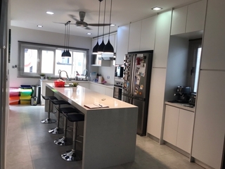 This elegant kitchen by Reccers Design & Build showcases a sleek, Scandinavian-inspired design. Part of the 'Jaqueline kitchen' makeover, this space blends classic and modern elements with minimalist charm. The bright, airy room features a crisp white and subtle grey color palette, stainless steel appliances, and a long kitchen island with chic pendant lighting and bar stools. The renovation reflects an efficient use of space reflective of Malaysian interior design trends.