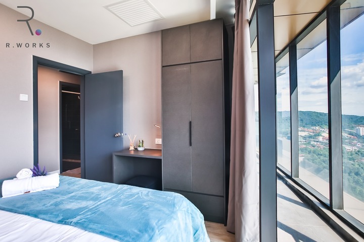 Modern Empire City hotel/homestay unit by R Works, featuring a sleek contemporary bedroom with panoramic views. Earthy tones blend with cool blues while natural light floods the space, highlighting the minimalist furniture and clean lines. Part of the 'Empire City Investor Units' project, this design encapsulates luxury and comfort in a compact setting.