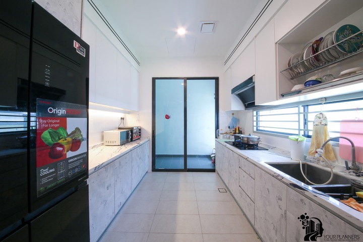 This image showcases a sleek, modern kitchen design by Your Planners（M）Sdn Bhd, from their Periwinkle - 35 project in Bandar Rimbayu. The minimalist layout features high-gloss cabinetry, stainless steel appliances, and crisp white walls complemented by subtle grey tones. The room is illuminated by natural light, accentuating clean lines and the well-organized space. Essential for those inspired by contemporary, functional interior design and custom furniture, this visual captures the essence of Your Planners' ability to turn dreams into reality. #ModernInterior #MinimalistKitchenDesign #YourPlanners #BandarRimbayuInteriorDesign