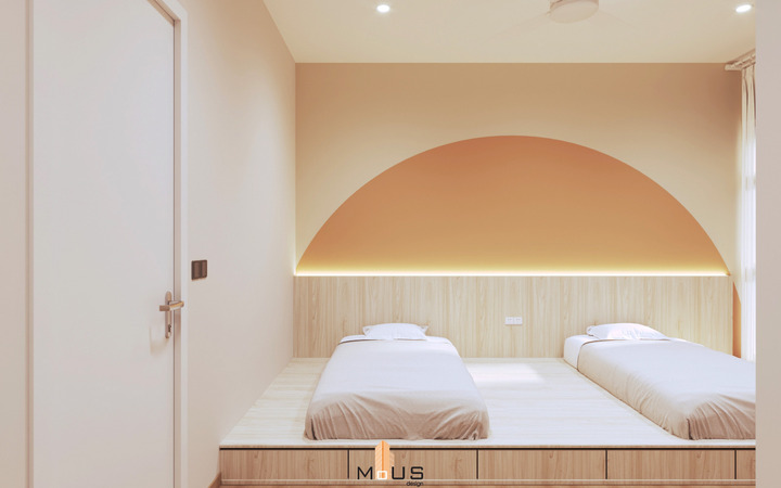 Experience contemporary elegance in this MOUS DESIGN-conceptualized bedroom at Ara Damansara Condominium in Malaysia. The room exudes a warm ambiance with a peach-toned arch accent wall above a plush double bed, complemented by modern minimalist furniture and soft, ambient lighting, reflecting a sophisticated sub sales house design and build by MOUS.
